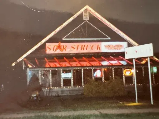 The Star Struck karaoke restaurant lit in neon at night.