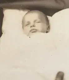 A sleeping infant wrapped in a blanket, a family photograph from around 1940.